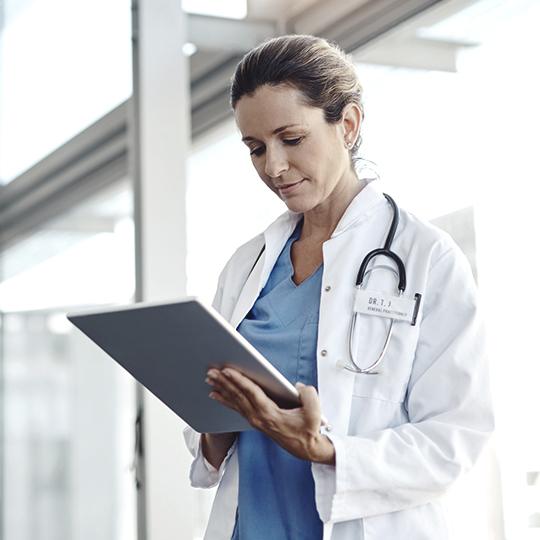 DMConnect - Professional workflows at your fingerprints Female doctor looking at laptop